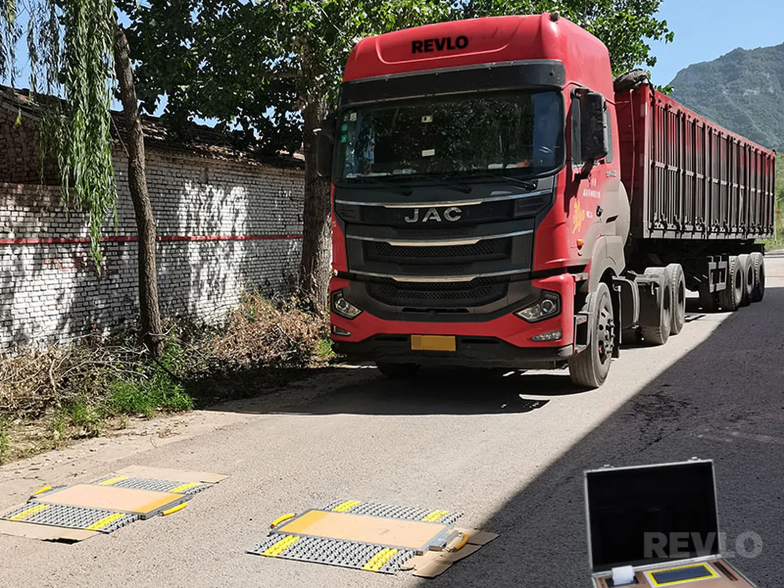 Caminhão passando sobre as plataformas da balança de sapata da Revlo