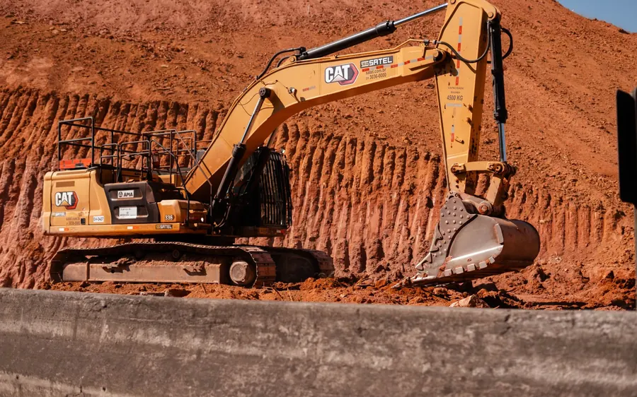 Heavy-duty excavator operating on a red earth construction site, ideal for industrial themes.