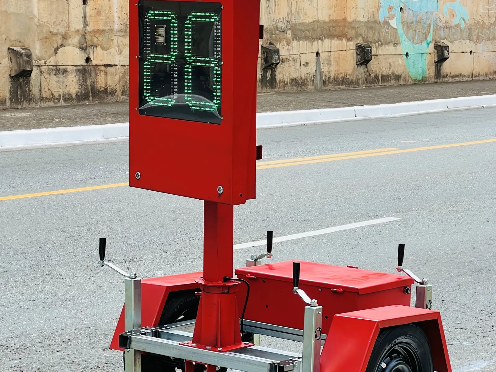 Lombada eletrônica móvel da Revlo em via urbana, com a velocidade no display