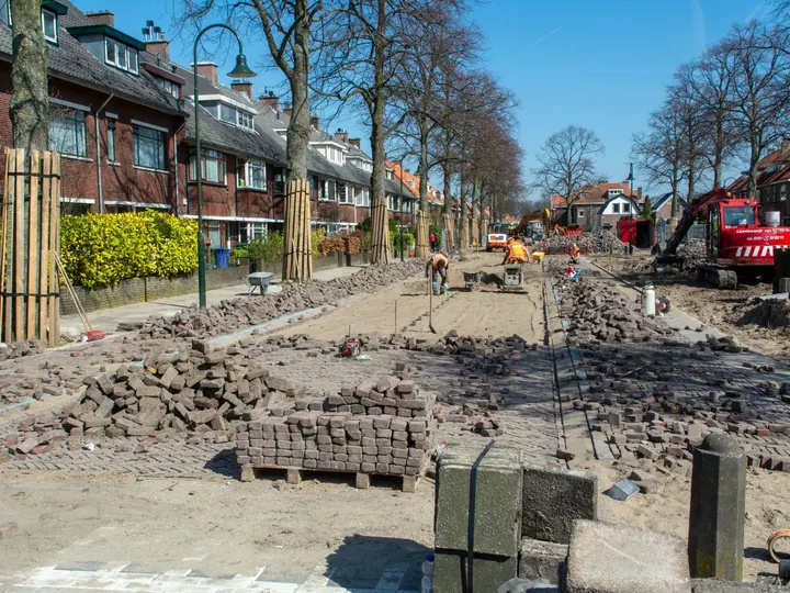 Construction of a brick-paved street in a residential neighborhood.