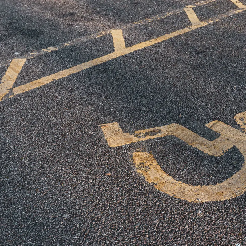 Prominent international wheelchair symbol on asphalt, illustrating accessibility.