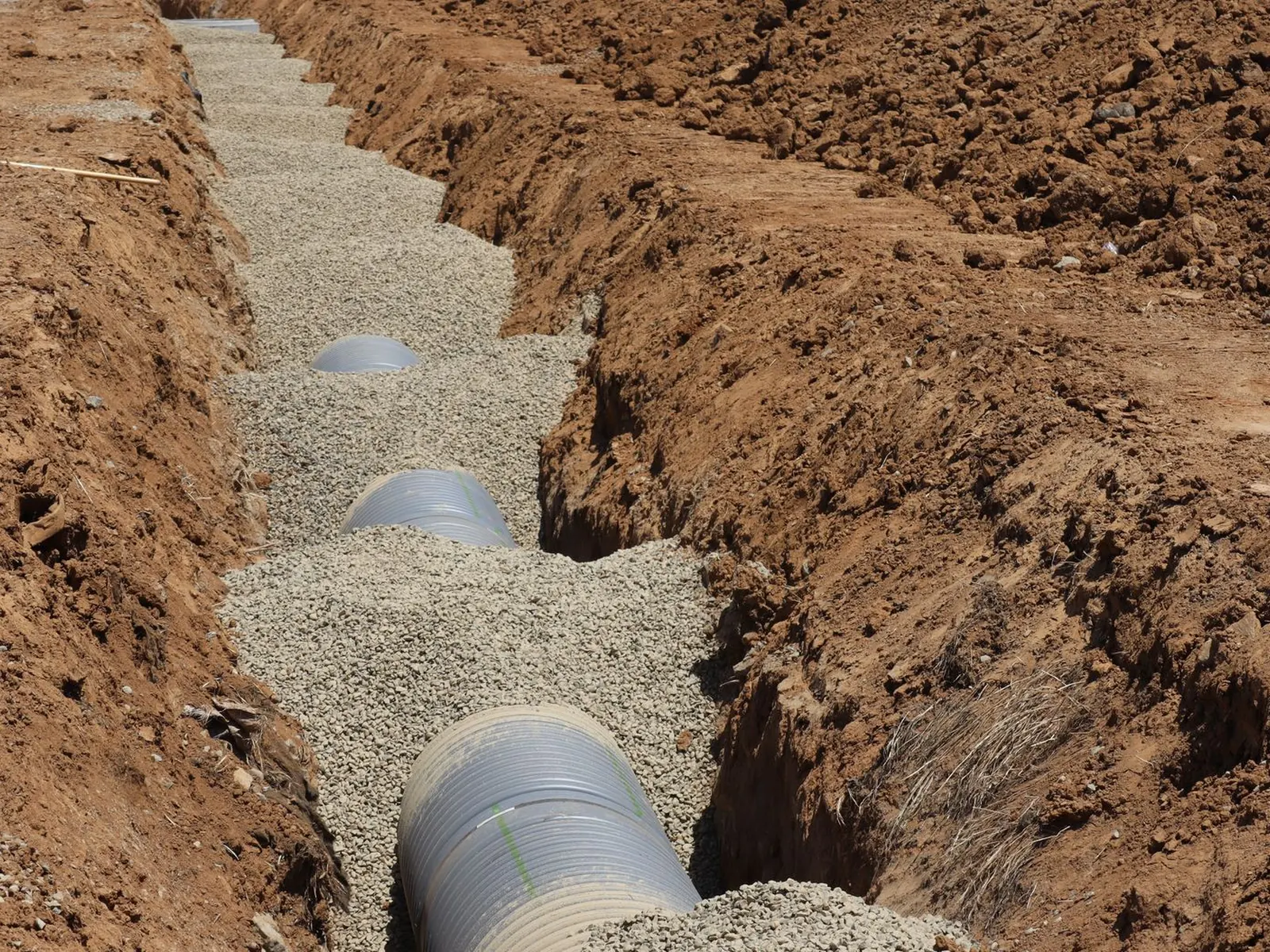 Detailed view of drainage pipe construction in a trench, Elk Grove, California.