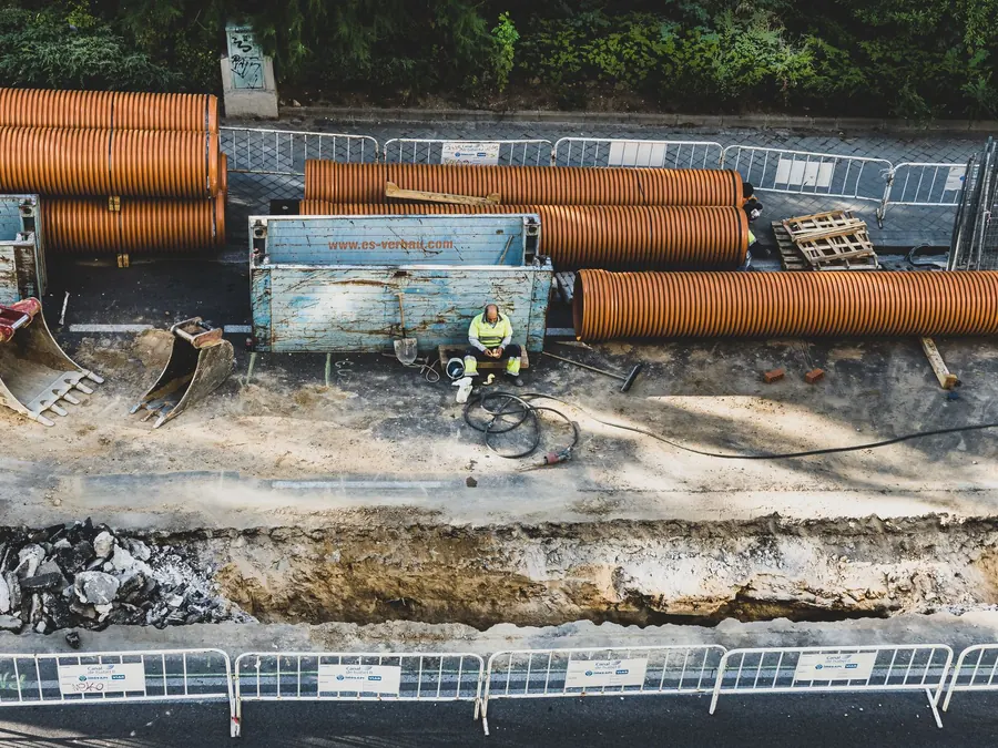 A construction worker takes a break at a site in Madrid, surrounded by equipment and materials.