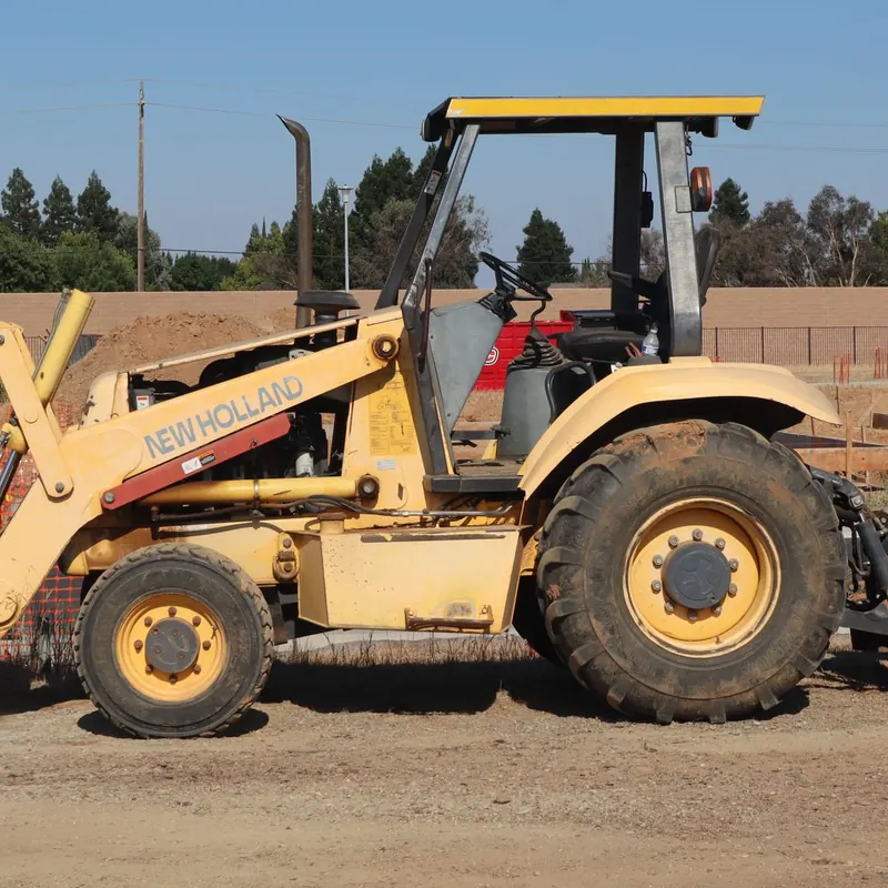 Yellow New Holland backhoe at a construction site in Elk Grove, California.